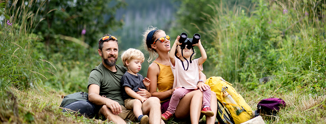 Familie sitzt zusammen im Gras im Urlaub